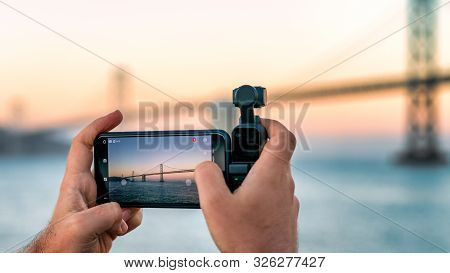 Usa, San Francisco - August 2019: A Photographer Is Using Osmo Pocket To Take Footage Of A Lake.