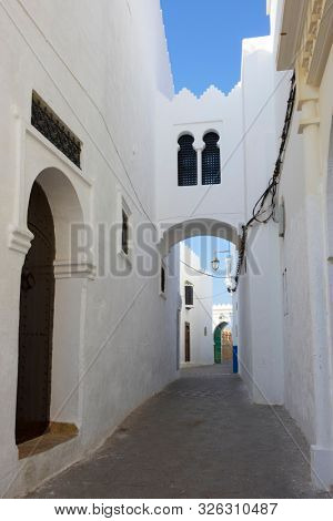 Narrow old street and gate in the medina of Asilah, Morocco