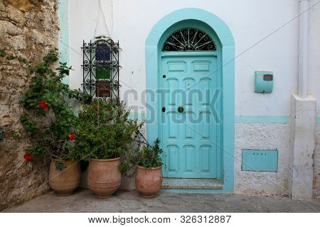 Facade of a traditional house with pot plants in the medina of Asilah, Morocco