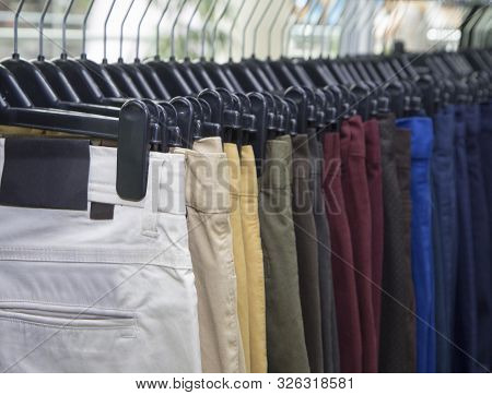 Elegant men clothing in a store, lots of pants elegant formal wear, gentleman style , autumn spring 
