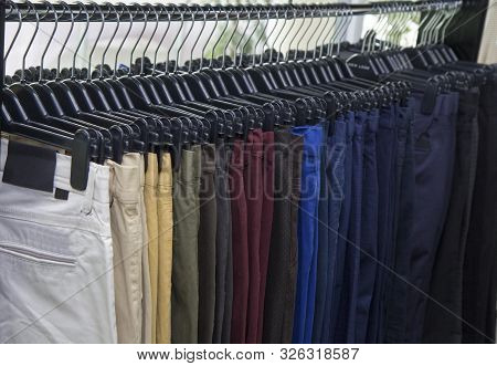 Elegant men clothing in a store, lots of pants elegant formal wear, gentleman style , autumn spring 