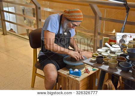 Bangkok, Thailand 08.23.2019: A Thai Artist Is Making A Clay Bowl Very Precisely At The Bangkok Art 