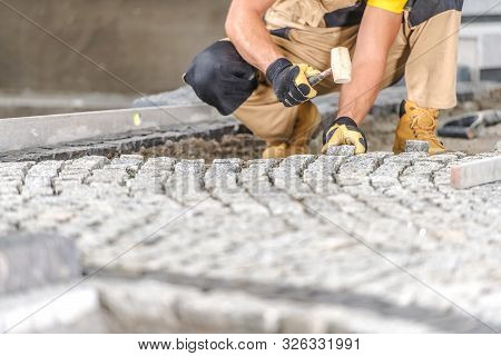 Residential Brick Driveway Paving By Caucasian Professional Worker. Construction Industry.