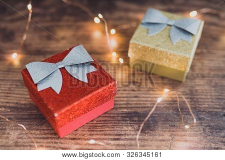 Christmas Present Box With Bow And Glitters Surrounded By Fairy Lights