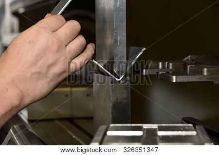 Worker Operating Metal Press Machine At Workshop. Bending Of Metal On The Machine.