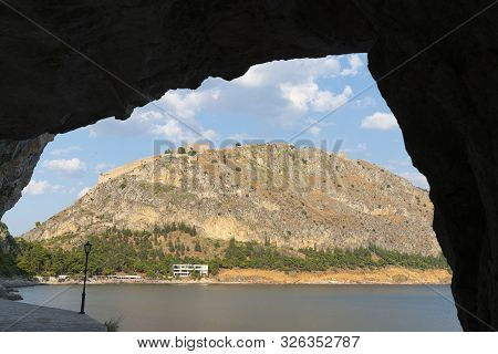 Rock Arch In Silhouette With View Through To Arvanitia Beach