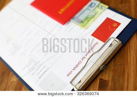 Red Passport Lie Against China Application Form Backgroung Cloceup.