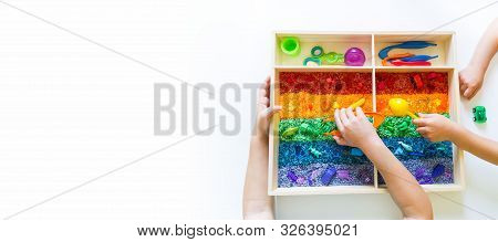Sensory Box With Rainbow Rice Inside. Montessori Material Baby Copy Space