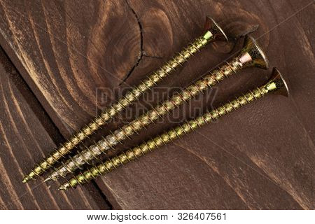 Group Of Three Whole Long Metallic Glossy Bolt Flatlay On Brown Wood