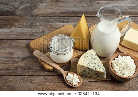 Different Delicious Dairy Products On Wooden Table