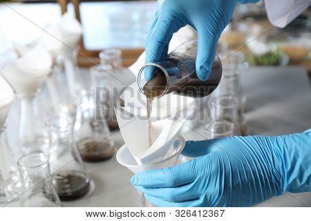 Scientist Filtering Soil Samples At Table, Closeup. Laboratory Analysis