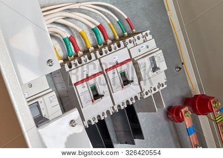 A Number Of Power Circuit Breakers In The Electrical Cabinet. White Cables Or Wires Are Attached To 