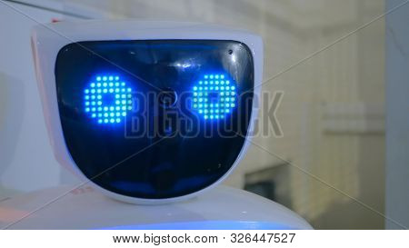 White Robot With Blue Eyes At Technology Exhibition. Future And Robotic Concept