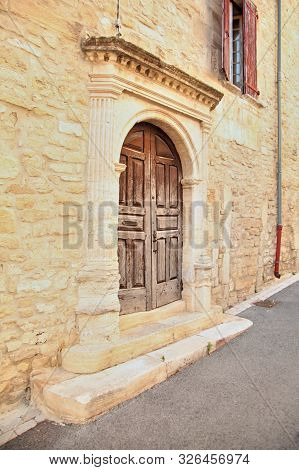 Old Wooden Closed Door In European Town, Decorated Entrance, Stone Wall Of Building