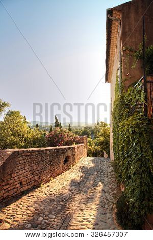 European Old Town With A Mediterranean Climate. Narrow Pedestrian Street With Stone Pavement And Bea