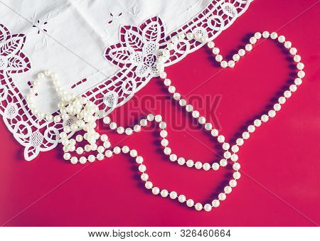 Romantic Background For Valentine`s Day With Pearl Necklace Heart And Lace On Red Background.