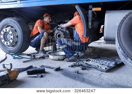 Two Mechanic Repairs A Truck. Replace Brake Disc And Pads
