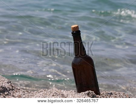 Bottle In Glass On The Beach By The Sera