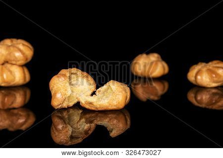 Group Of Four Whole Two Halves Of Baked Golden Profiterole Isolated On Black Glass