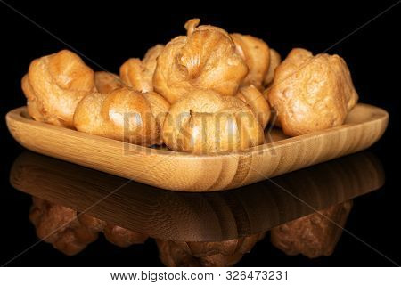 Lot Of Whole Baked Golden Profiterole On Wooden Square Plate Isolated On Black Glass