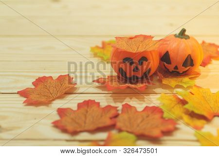 Halloween Pumpkins With Painted Faces On A Wooden Table. Halloween Background. Space For Text. Copy