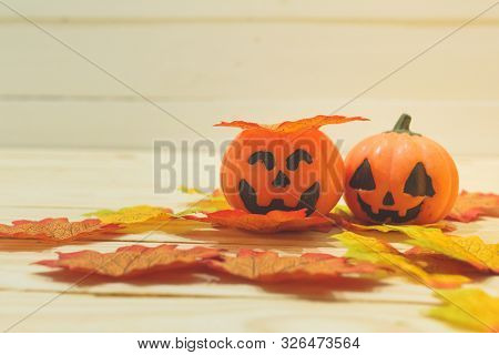 Halloween Pumpkins With Painted Faces On A Wooden Table. Halloween Background. Space For Text. Copy
