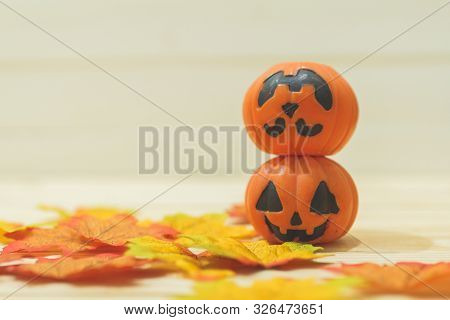Halloween Pumpkins With Painted Faces On A Wooden Table. Halloween Background. Space For Text. Copy