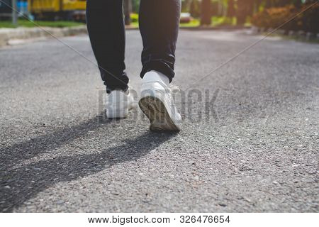 Step Walk Woman Jeans And Sneaker Shoes Walking On The Road.