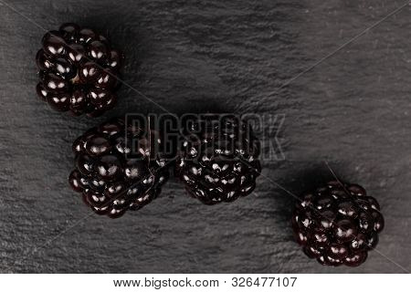 Group Of Four Whole Fresh Black Blackberry Flatlay On Grey Stone