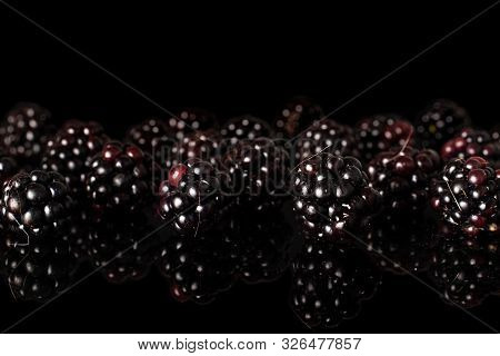 Lot Of Whole Disordered Fresh Black Blackberry Isolated On Black Glass