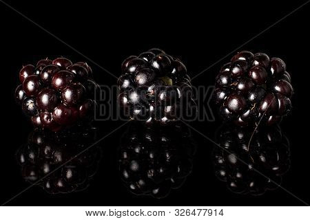 Fresh Black Blackberry Isolated On Black Glass