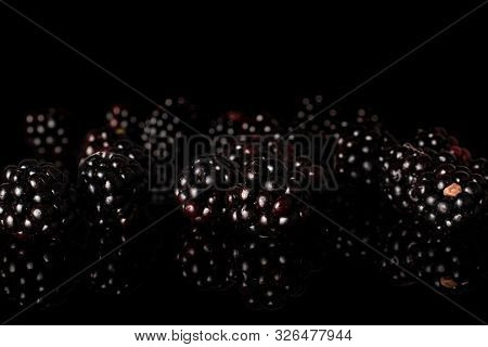 Lot Of Whole Disordered Fresh Black Blackberry Isolated On Black Glass