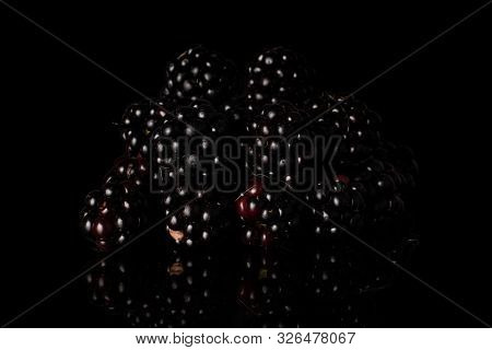 Lot Of Whole Fresh Black Blackberry Heap Isolated On Black Glass