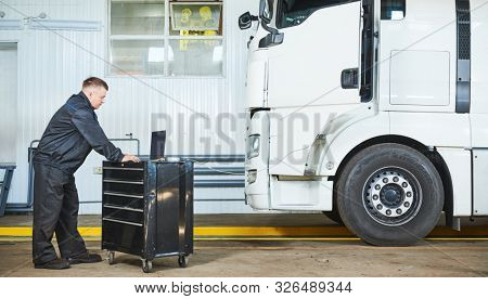 Truck repair service. Mechanic makes computer diagnostic of the semitruck