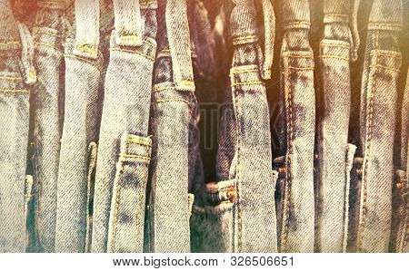 Worn Jeans In Wardrobe Or On Store Hanger. Vintage Jeans Retro Style Photo. Streetwear On Hanger In 