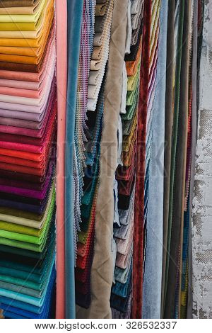 Many Fabrics Of Different Types. Colorful Fabric Swatches On Shopfront. Textile Samples Background.