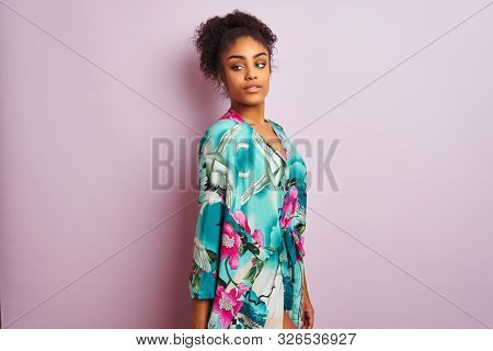 Young beautiful african american woman standing wearing elegant colorful caftan