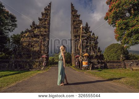 Tourist Woman Walking Through Traditional Balinese Hindu Gate Candi Bentar Close To Bedugul, Bratan 