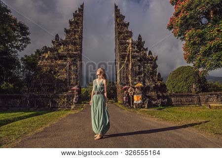 Tourist Woman Walking Through Traditional Balinese Hindu Gate Candi Bentar Close To Bedugul, Bratan 