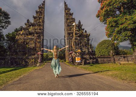 Tourist Woman Walking Through Traditional Balinese Hindu Gate Candi Bentar Close To Bedugul, Bratan 
