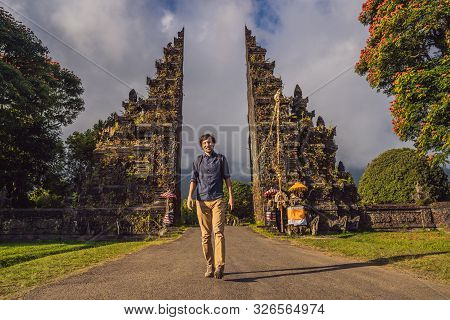 Tourist Man Walking Through Traditional Balinese Hindu Gate Candi Bentar Close To Bedugul, Bratan La