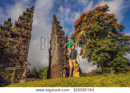 Father And Son Walking Through Traditional Balinese Hindu Gate Candi Bentar Close To Bedugul, Bratan
