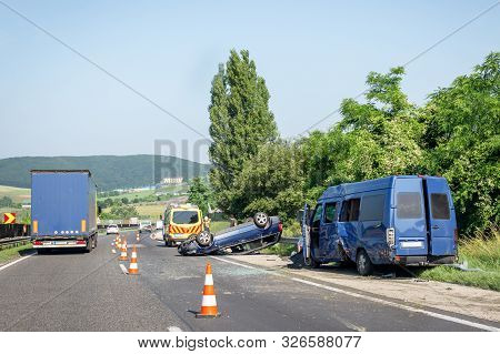Car Crash Accident On Highway. Damaged Blue Minibus After Collision, Overturned Car And Ambulance Ca