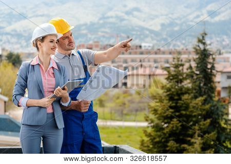 Property developer and construction worker creating project together envisaging the future