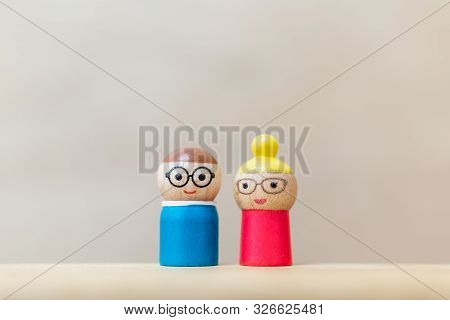 Wooden Doll With  Happy Face On Wooden Background.
