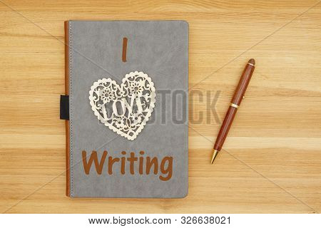 I Love Writing Message With Gray Leather Book With Heart And Pen On A Wood Desk