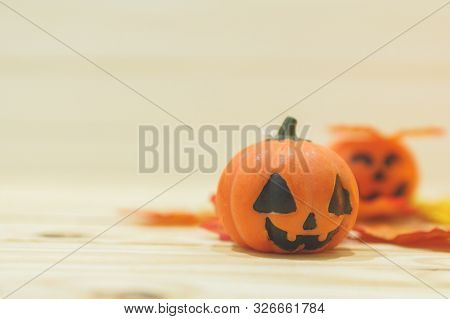 Halloween Pumpkins With Painted Faces On A Wooden Table. Halloween Background. Space For Text. Copy