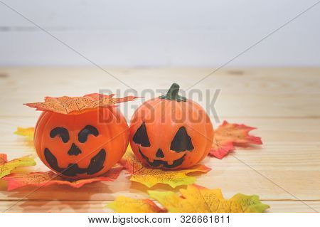 Halloween Pumpkins With Painted Faces On A Wooden Table. Halloween Background. Space For Text. Copy 