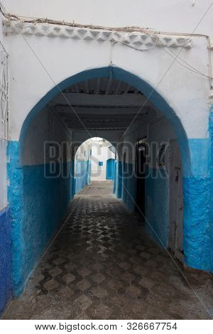Narrow old street and gate in the medina of Asilah, Morocco
