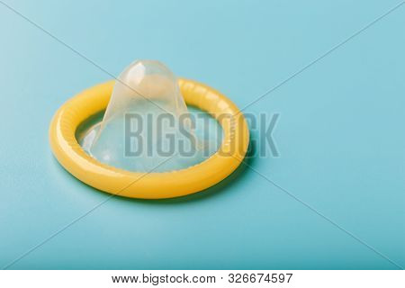 Opened Condom On A Blue Background. Use Of Protection To Reduce The Likelihood Of Sexually Transmitt